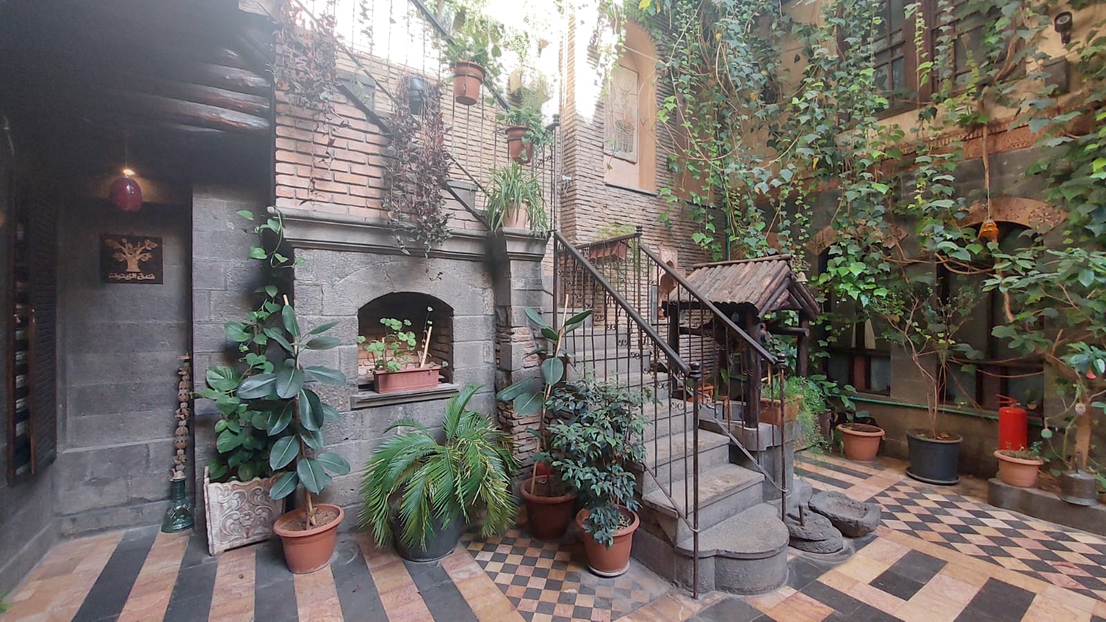 A plant-filled courtyard with stone steps in Syria